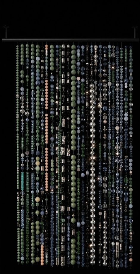 Custom beaded door curtain hanging on a rod against a full black background